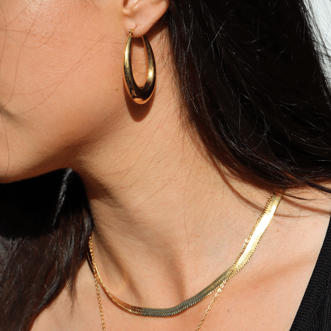 model wears delta gol plated statement hoops and gold plate Valentina snake chain necklace